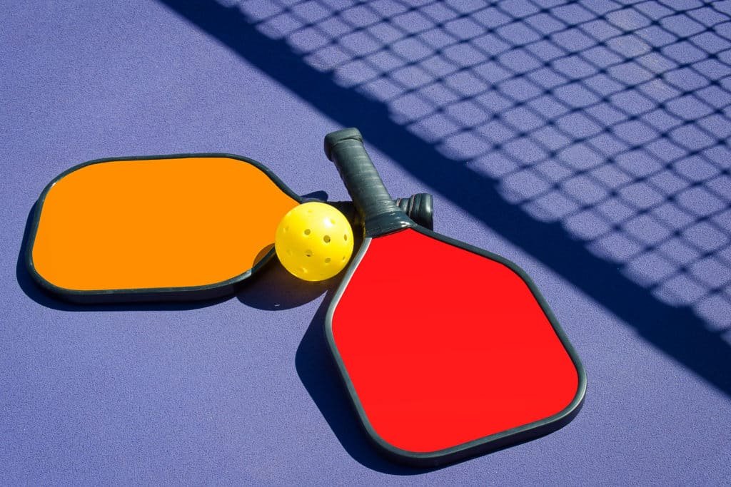 2 Pickleball paddles and a pickleball 