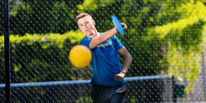 Male pickleball player returning ball with lots of spin