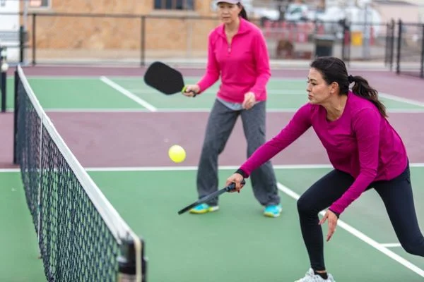 Two women playing pickleball doubles